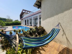 a blue hammock sitting in front of an airbnb property